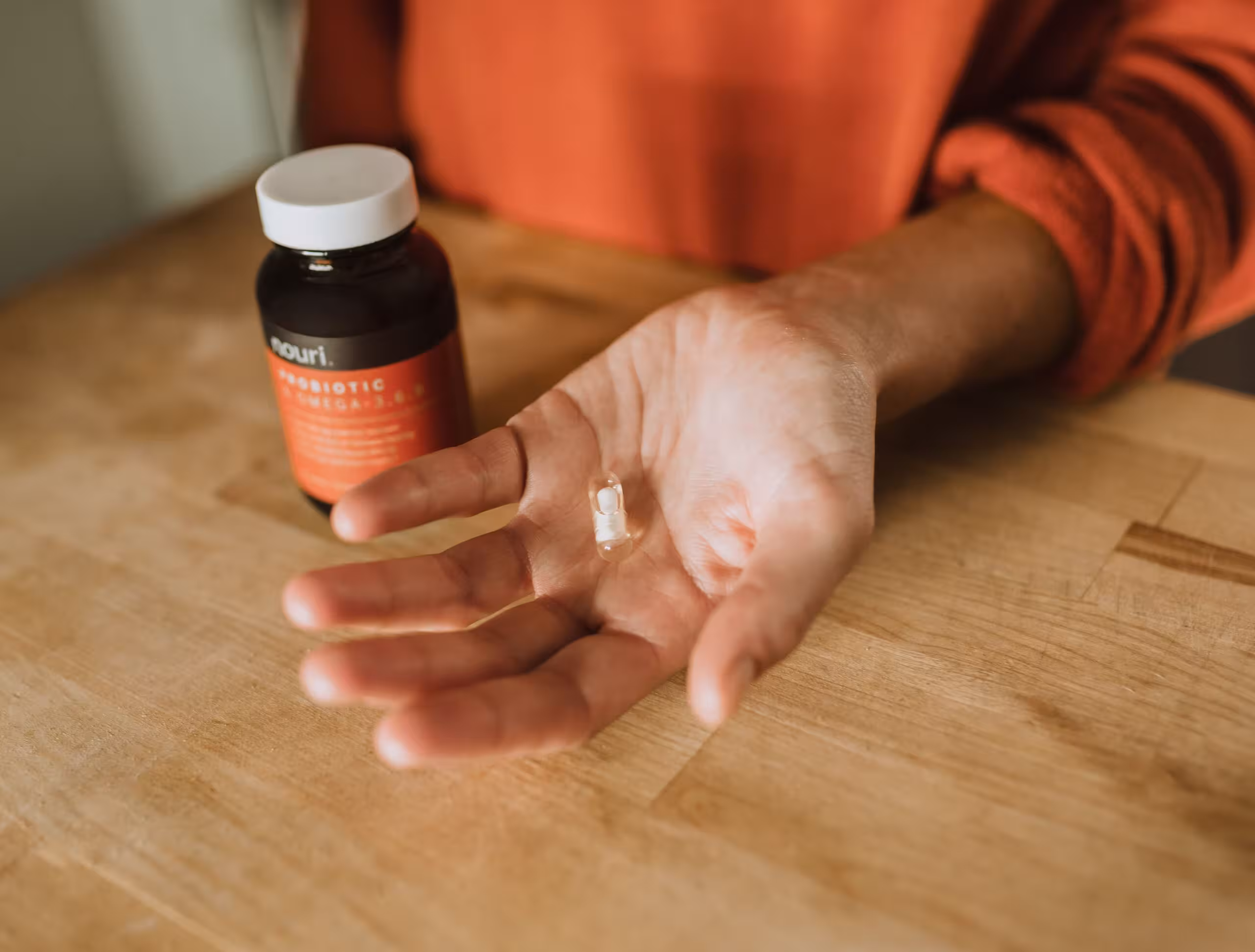 Hand holding a white pill